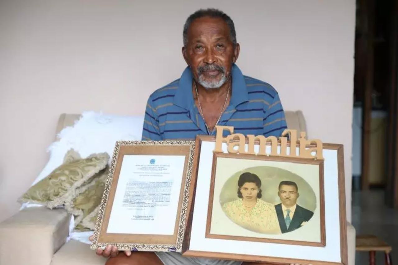 Retrato de Olívio com a fotografia dos pais e a certificação do quilombo Créditos: Carlos Jr/ND, reprodução.